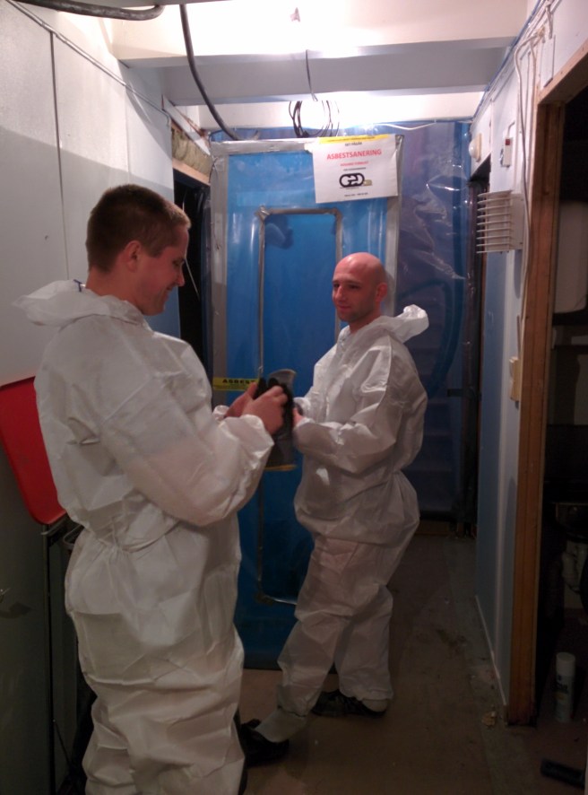 Arbeiderne gjør seg klare for en ny runde med asbestfjerning. Luftslusen i bakgrunnen.